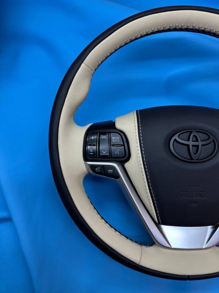 Левая часть руля Toyota после перетяжки в светлую и чёрную кожу